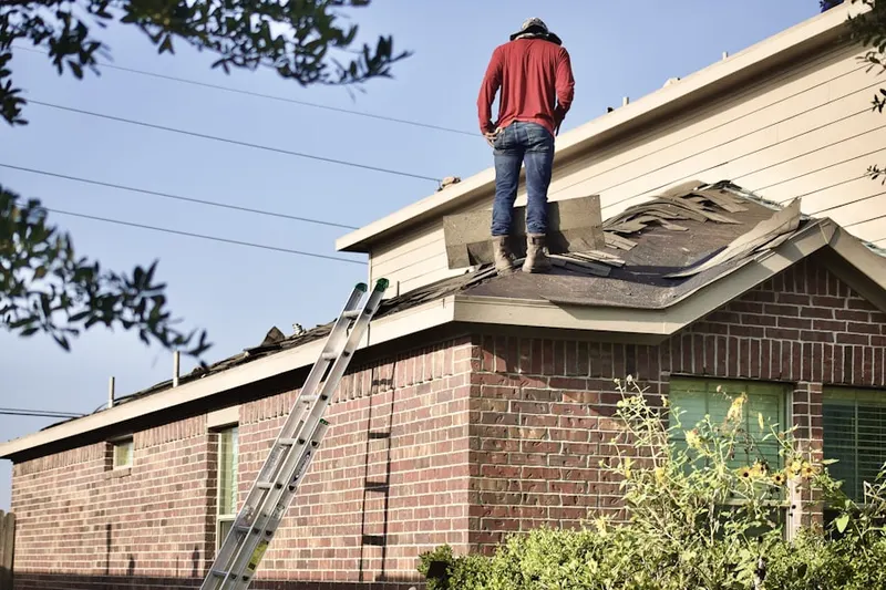Professional roofer working on a residential roof in Schofer